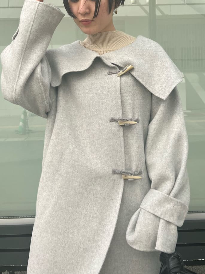 レッド系のブーツ、グレー系のダッフルコート、グレー系のダッフルコートを着用したレディースの秋コーディネートの3枚目の写真