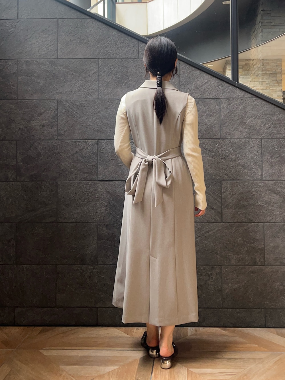 ブラウン系のパンプス、グレー系のワンピース、ホワイト系のニット/セーターを着用したレディースの秋コーディネートの3枚目の写真