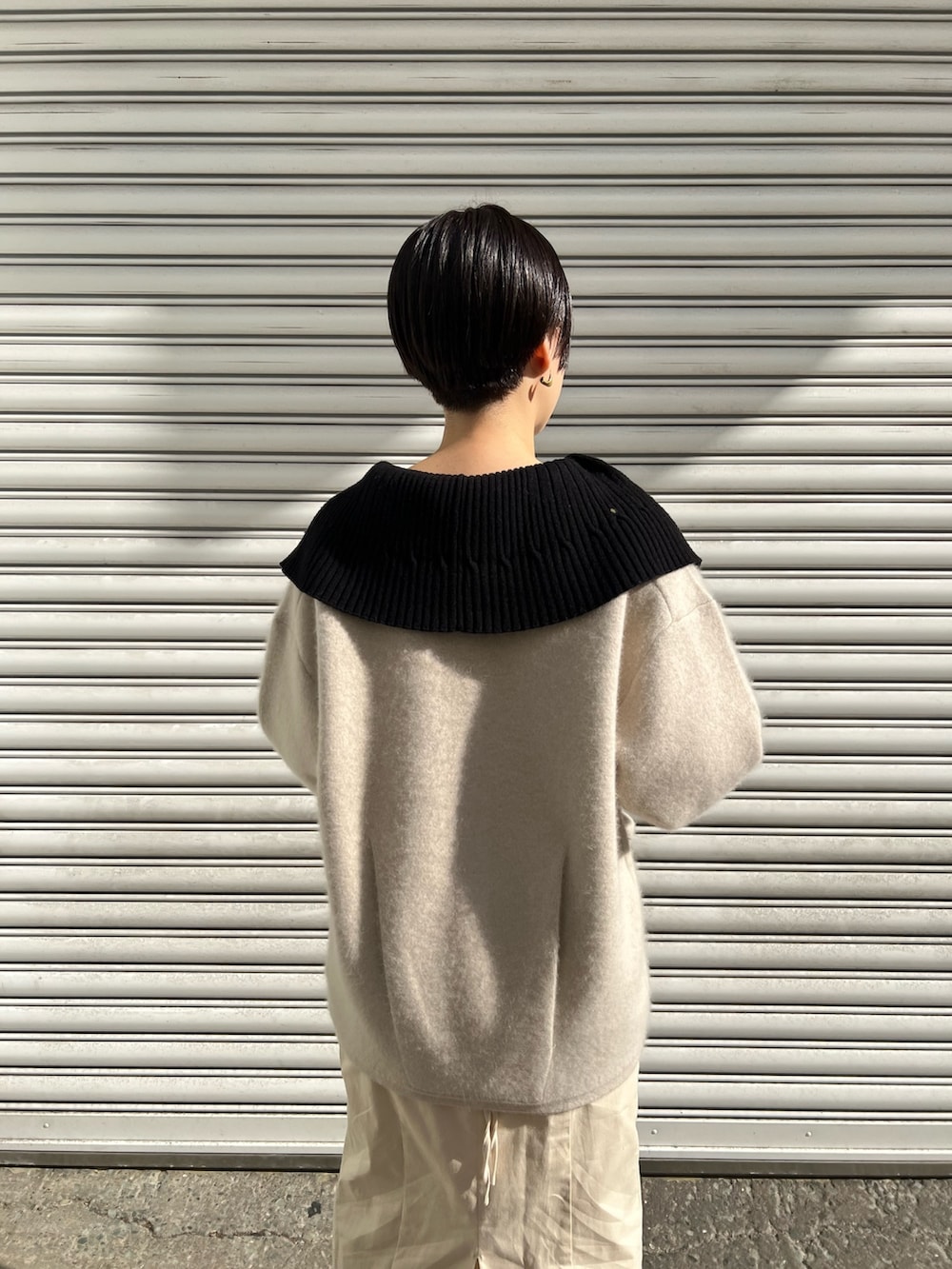 レッド系のブーツ、ホワイト系のスカート、ホワイト系のカーディガン/ボレロを着用したレディースの冬コーディネートの3枚目の写真