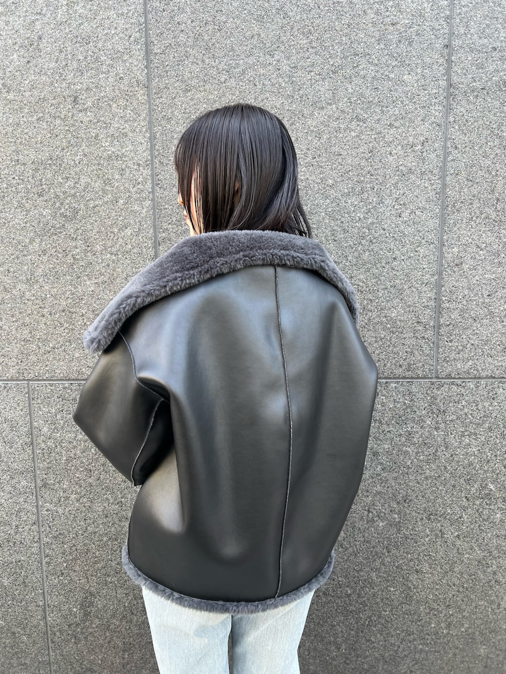 グレー系のムートンコート、ブルー系のデニムパンツを着用したレディースの冬コーディネートの6枚目の写真