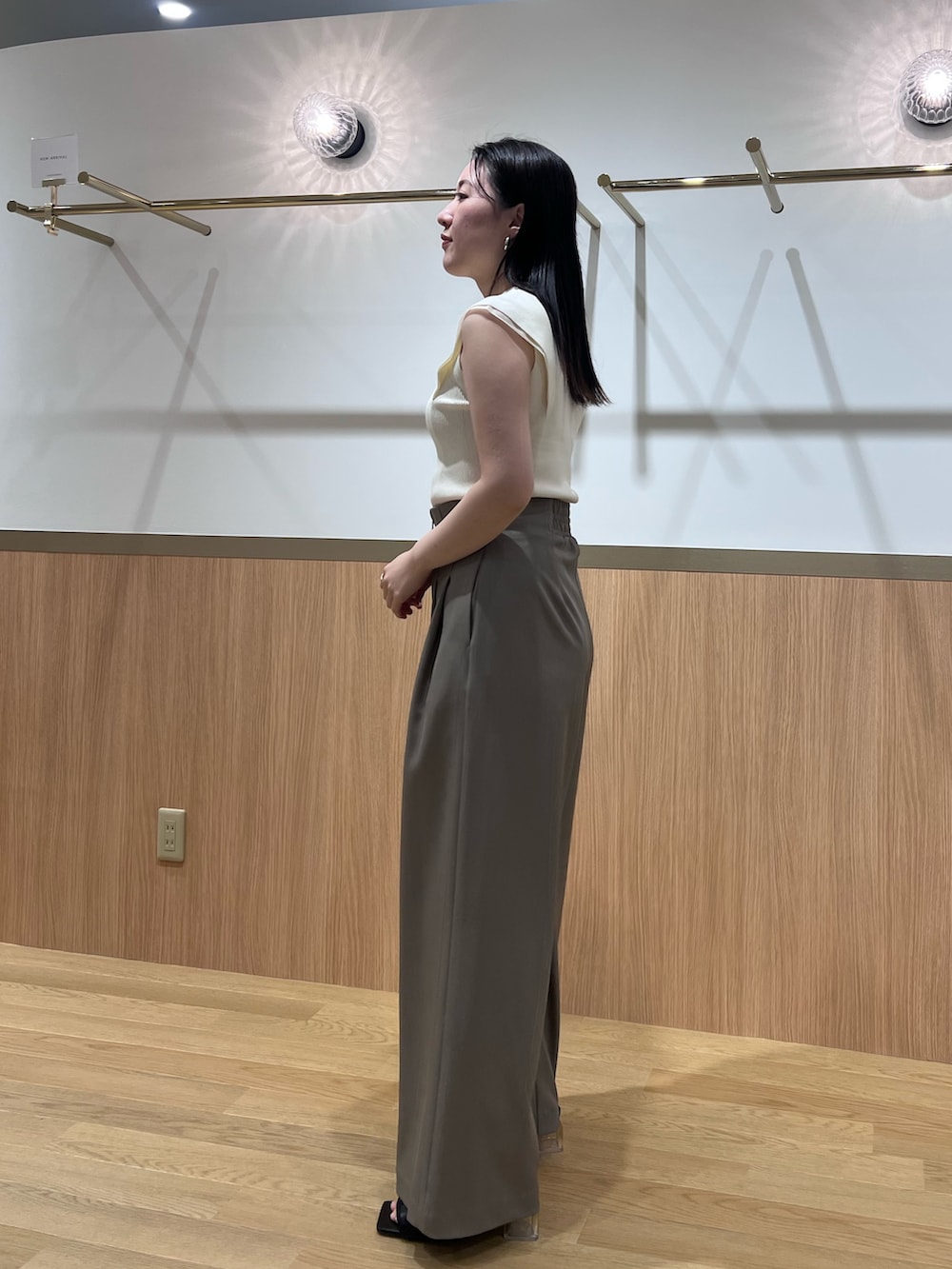 ブラウン系のその他パンツ、ブラック系のサンダル、ホワイト系のニット/セーターを着用したレディースの春コーディネートの2枚目の写真