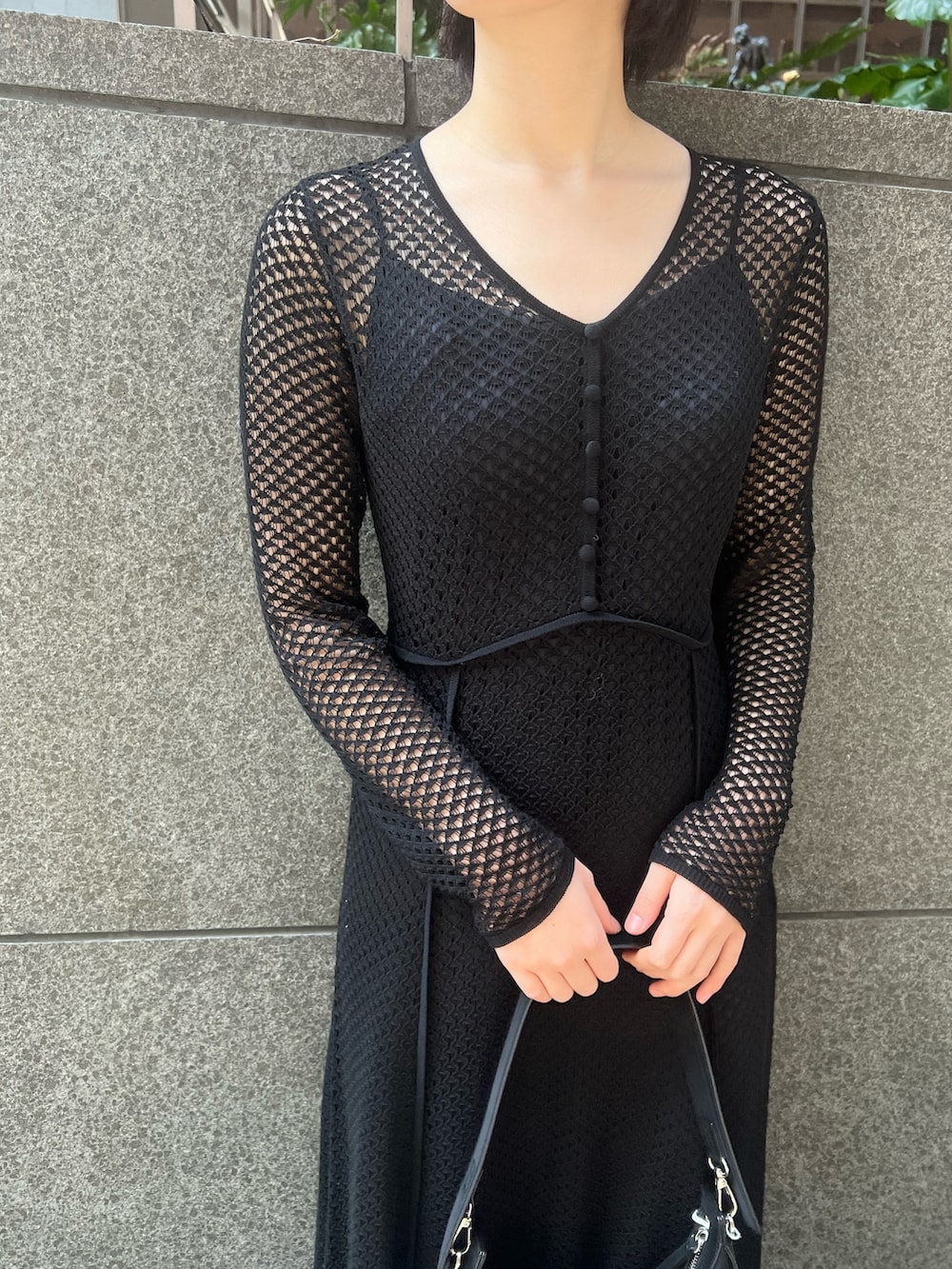 ブラック系のデニムジャケット、ホワイト系のパンプス、ブラック系のハンドバッグを着用したレディースの春コーディネートの6枚目の写真