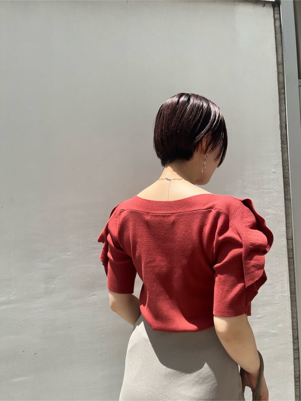 ベージュ系のハンドバッグ、ホワイト系のサンダル、ベージュ系のスカートを着用したレディースの夏コーディネートの5枚目の写真