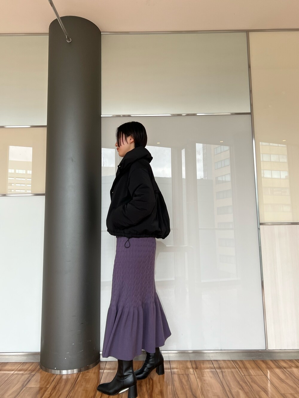 ブラック系のダウンジャケット/コート、ブラック系のブーツ、パープル系のワンピースを着用したレディースの冬コーディネートの2枚目の写真