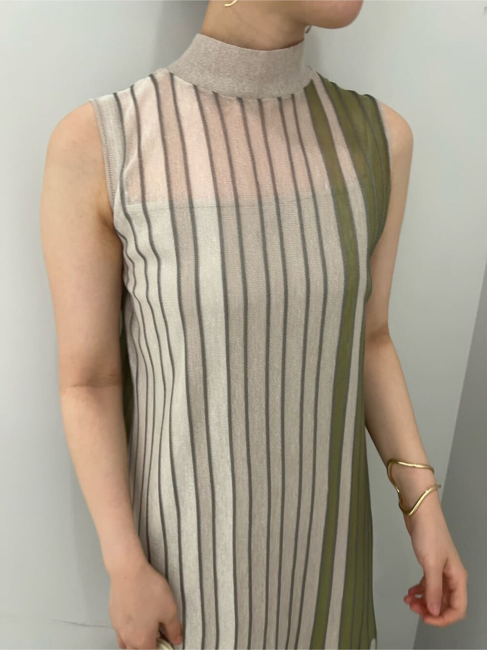 グリーン系のワンピース、グリーン系のサンダル、ゴールド系のピアス（両耳用）を着用したレディースの夏コーディネートの4枚目の写真