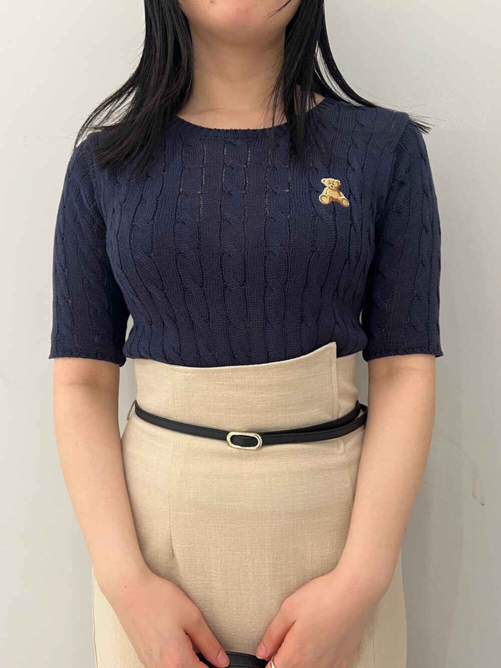 ブルー系のニット/セーター、ホワイト系のサンダル、ベージュ系のスカートを着用したレディースの春コーディネートの4枚目の写真