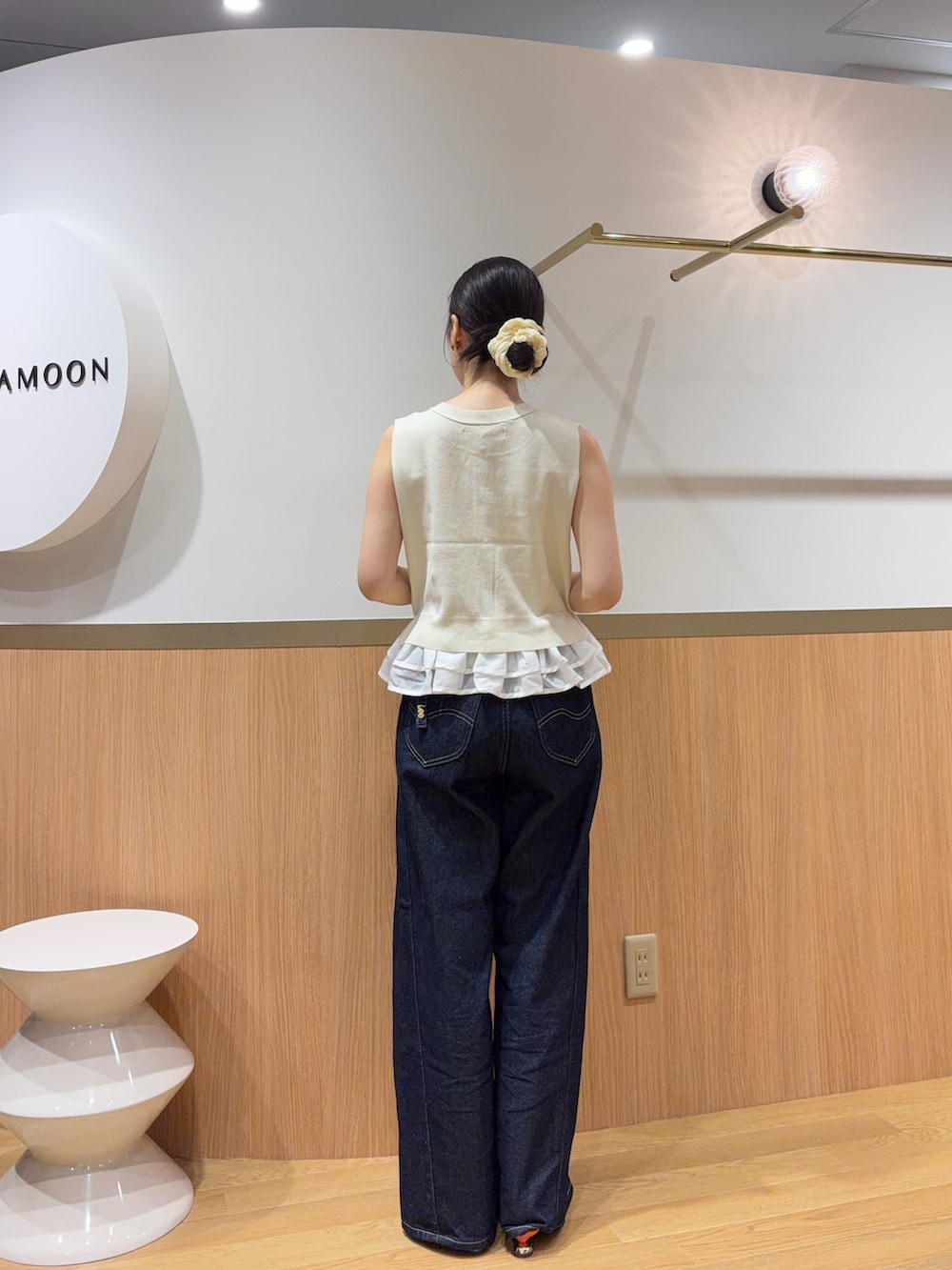 ホワイト系のニット/セーター、オレンジ系のサンダル、ブルー系のデニムパンツを着用したレディースの夏コーディネートの3枚目の写真