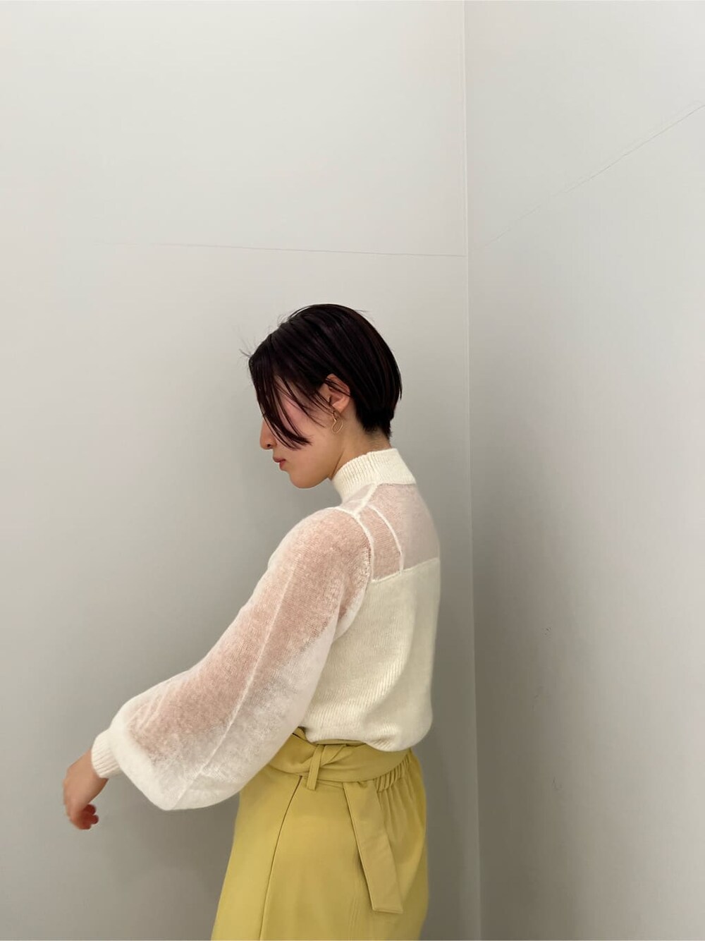 ベージュ系のその他シューズ、ホワイト系のニット/セーター、イエロー系のスカートを着用したレディースの冬コーディネートの4枚目の写真