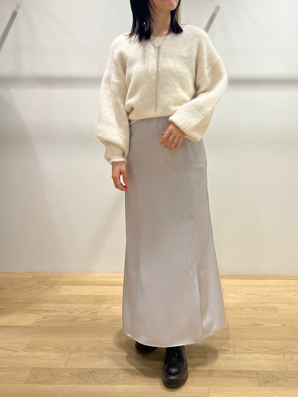 ホワイト系のニット/セーター、グレー系のブルゾン、ブラック系のブーツを着用したレディースの冬コーディネートの2枚目の写真