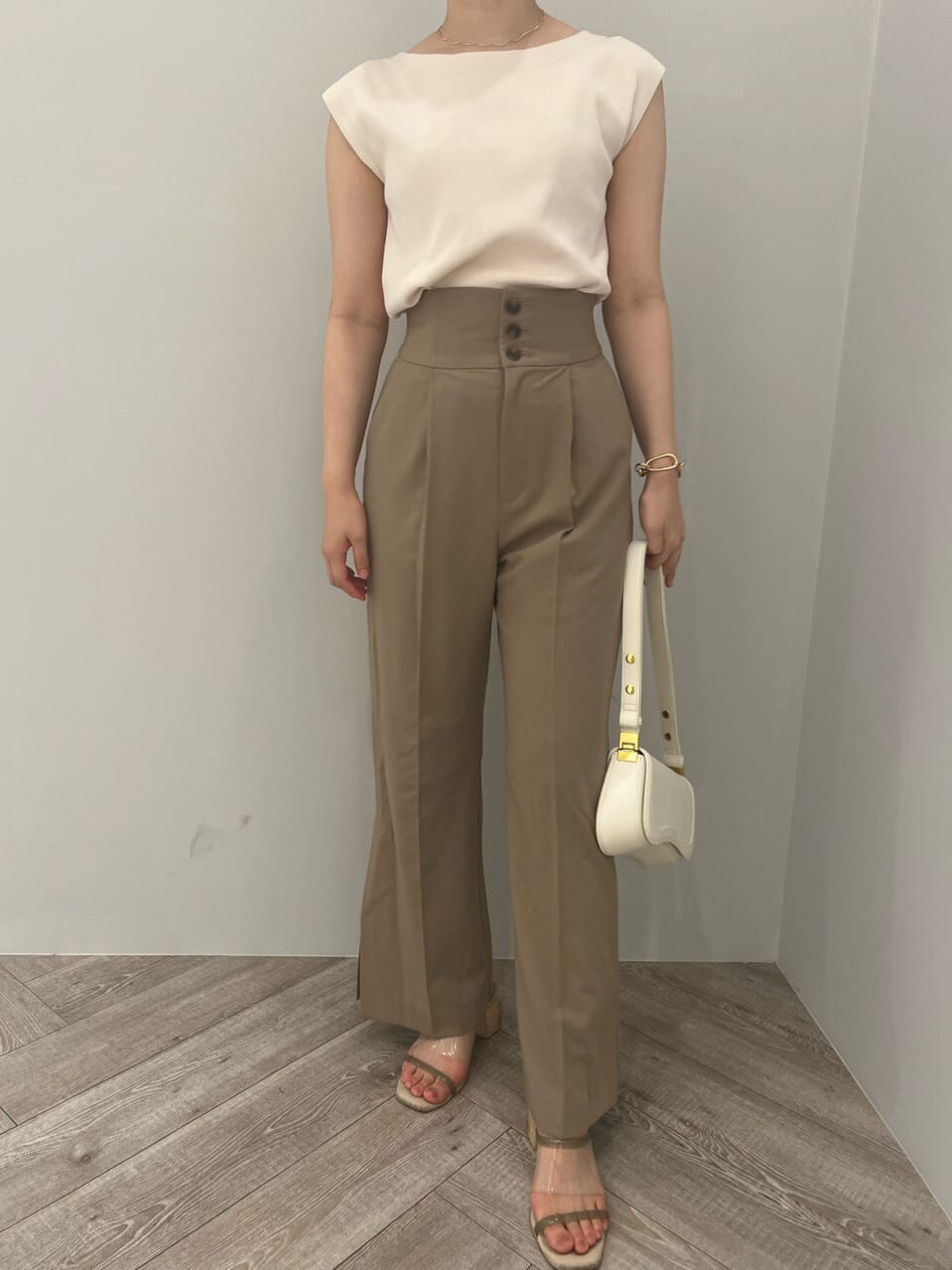 ベージュ系のその他パンツ、ホワイト系のニット/セーター、ホワイト系のショルダーバッグを着用したレディースの夏コーディネートの3枚目の写真