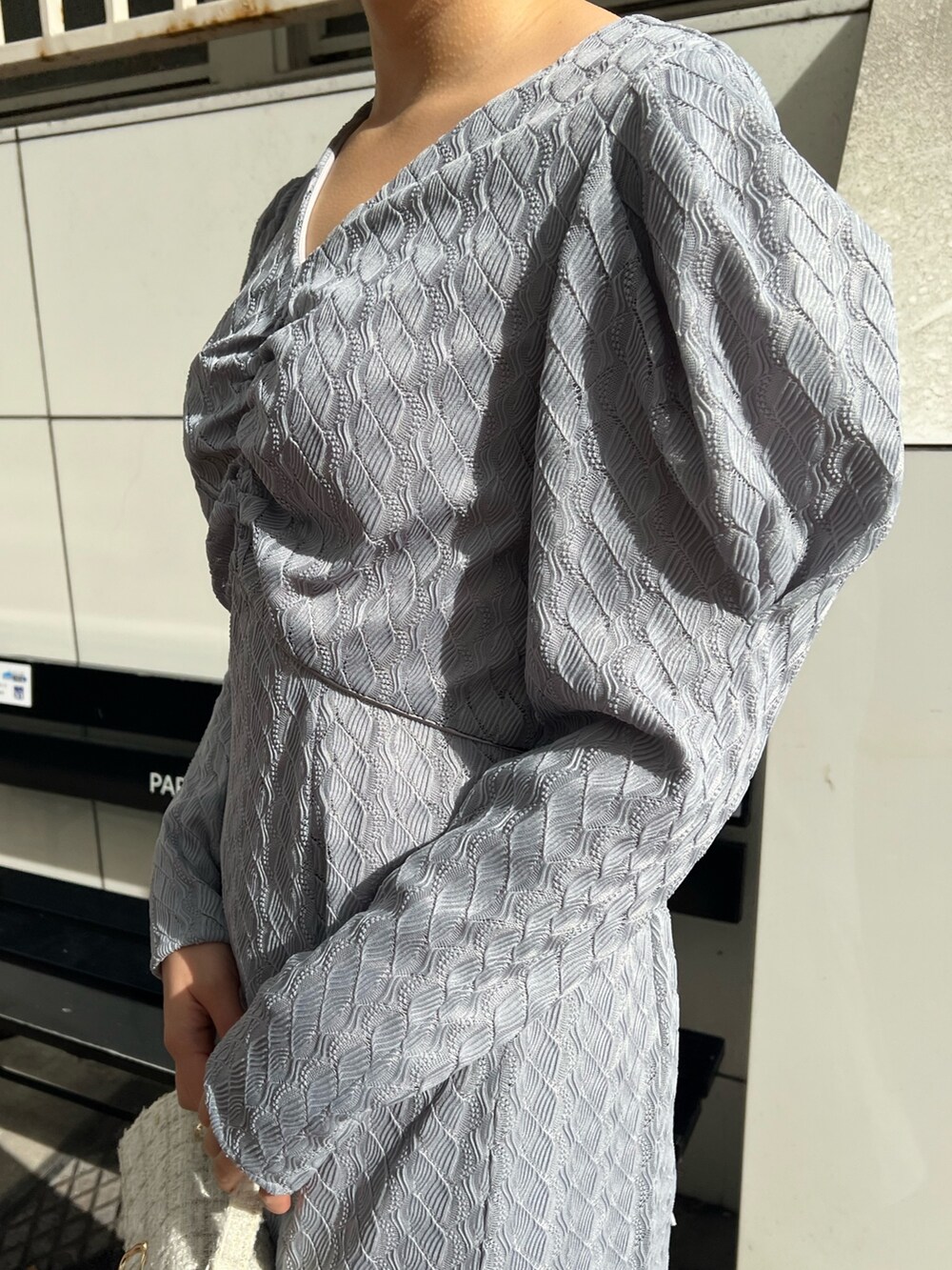 ホワイト系のショルダーバッグ、ベージュ系のブーツ、ベージュ系のその他アウターを着用したレディースの冬コーディネートの9枚目の写真