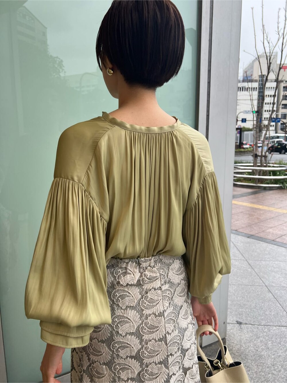 ホワイト系のハンドバッグ、ホワイト系のパンプス、グリーン系のシャツ/ブラウスを着用したレディースの春コーディネートの8枚目の写真