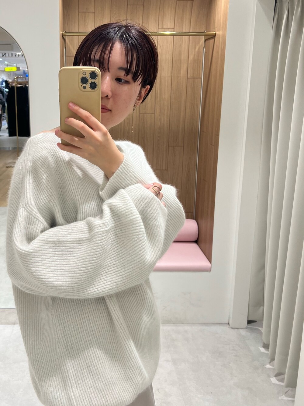 ベージュ系のスニーカー、ホワイト系のニット/セーター、ホワイト系のスカートを着用したレディースの秋コーディネートの4枚目の写真