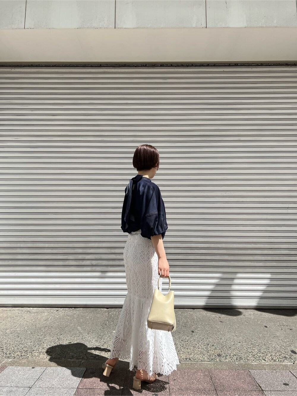 ホワイト系のハンドバッグ、ブルー系のシャツ/ブラウス、ホワイト系のスカートを着用したレディースの春コーディネートの8枚目の写真