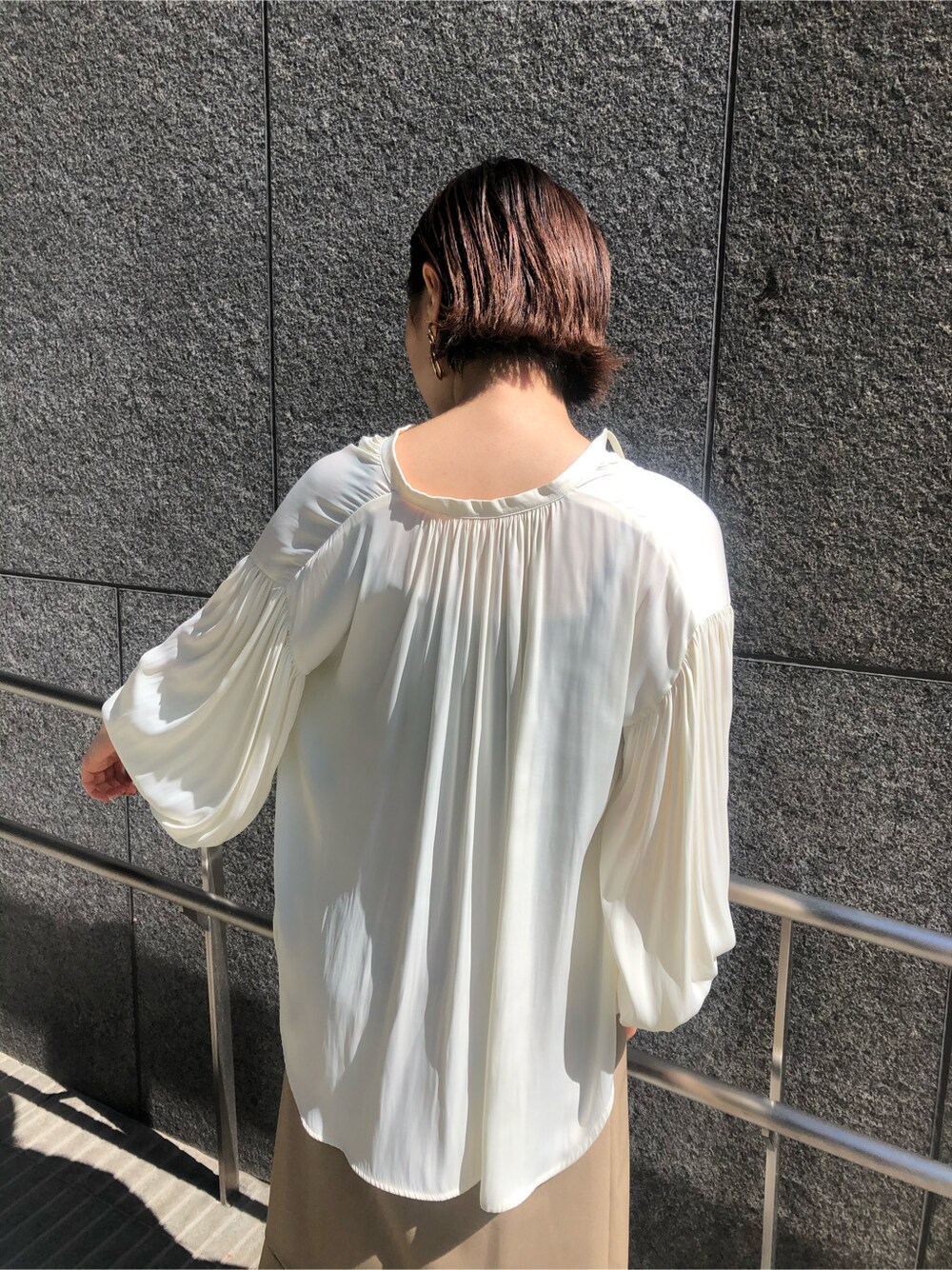 ホワイト系のシャツ/ブラウス、ベージュ系のスカート、ホワイト系のハンドバッグを着用したレディースの春コーディネートの5枚目の写真