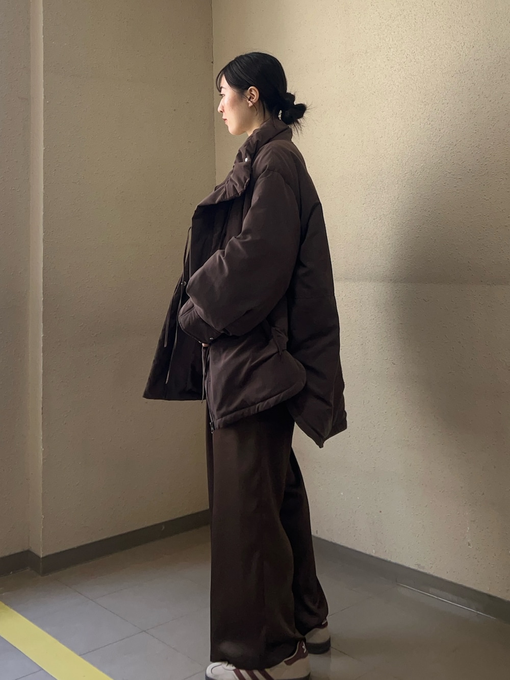 ベージュ系のニット/セーター、ブラウン系のダウンジャケット/コート、ブラウン系のその他パンツを着用したレディースの冬コーディネートの2枚目の写真