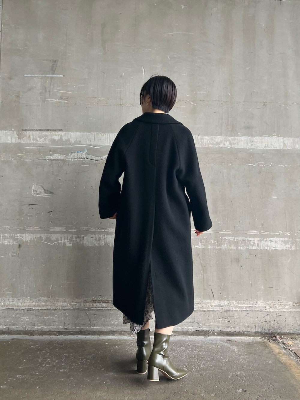 ベージュ系のブーツ、ブラック系のその他アウター、ホワイト系のワンピースを着用したレディースの冬コーディネートの3枚目の写真