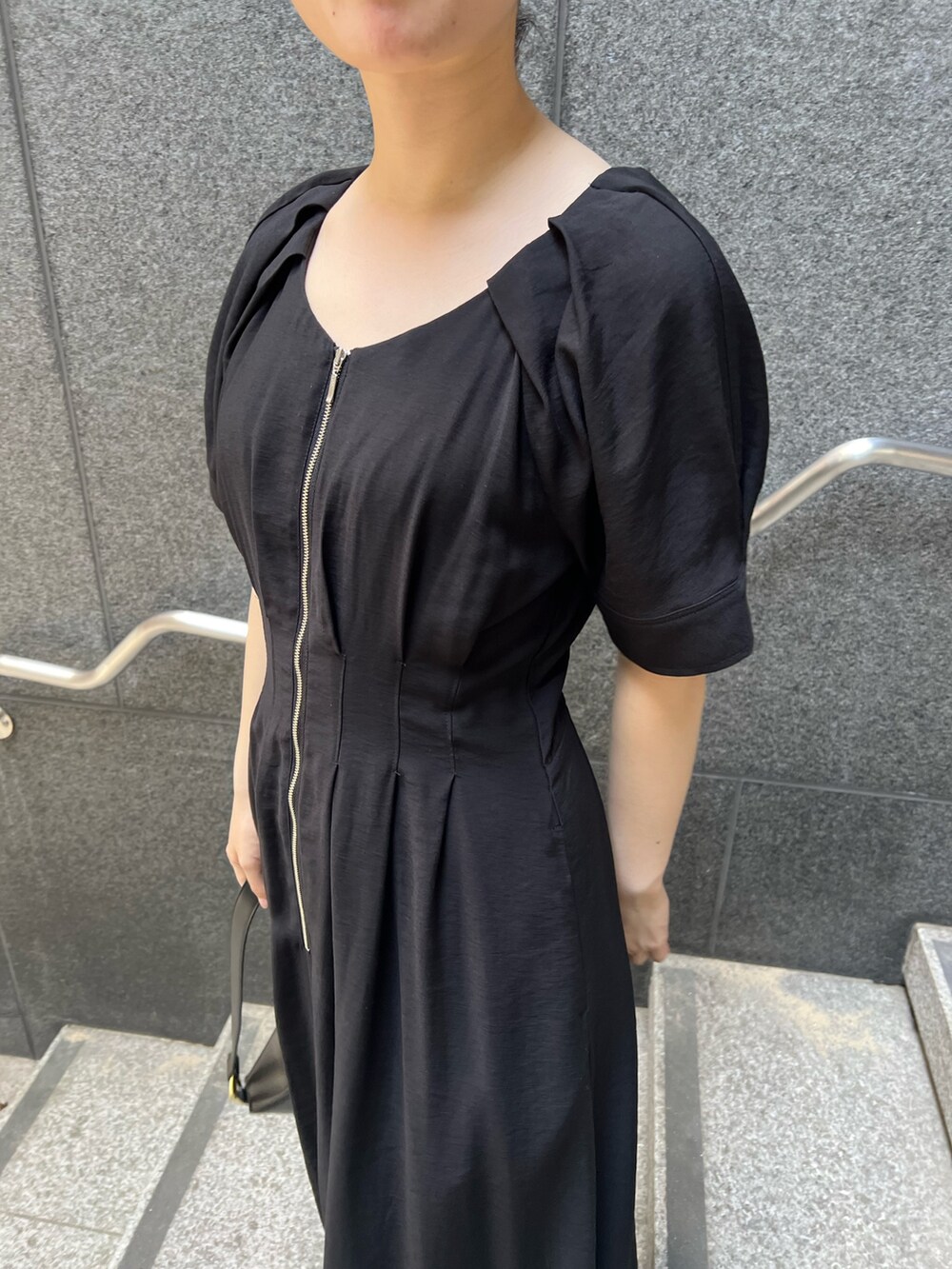 ブラック系のワンピース、ブラック系のショルダーバッグ、シルバー系のパンプスを着用したレディースの夏コーディネートの4枚目の写真