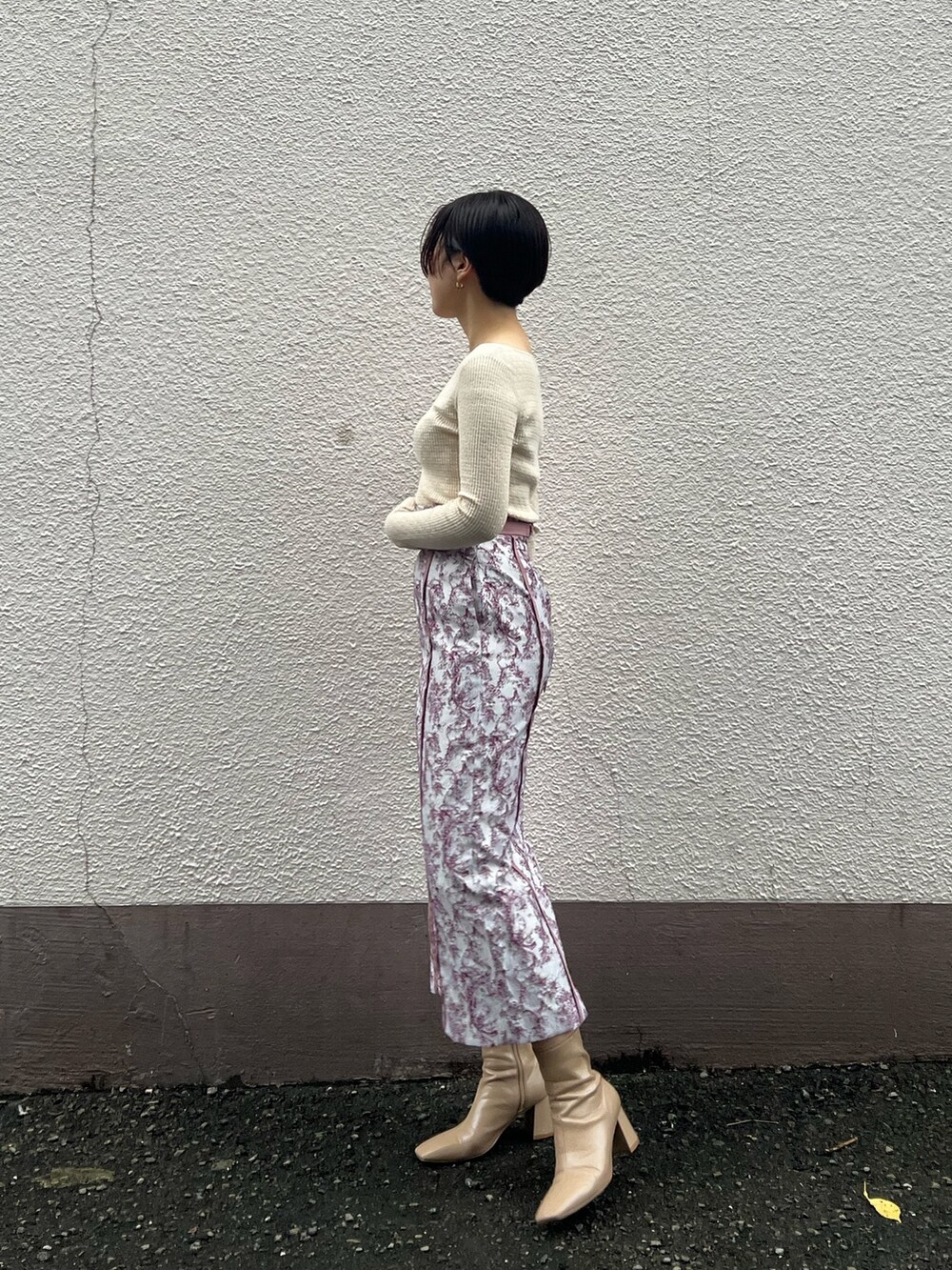 ベージュ系のブーツ、ベージュ系のその他アウター、ホワイト系のニット/セーターを着用したレディースの秋コーディネートの5枚目の写真