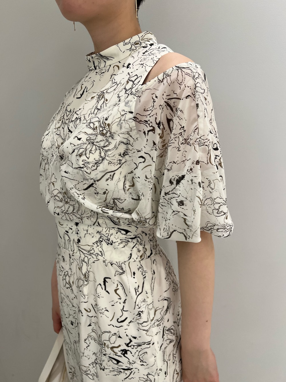 ブラウン系のサンダル、ホワイト系のショルダーバッグ、ホワイト系のワンピースを着用したレディースの春コーディネートの5枚目の写真