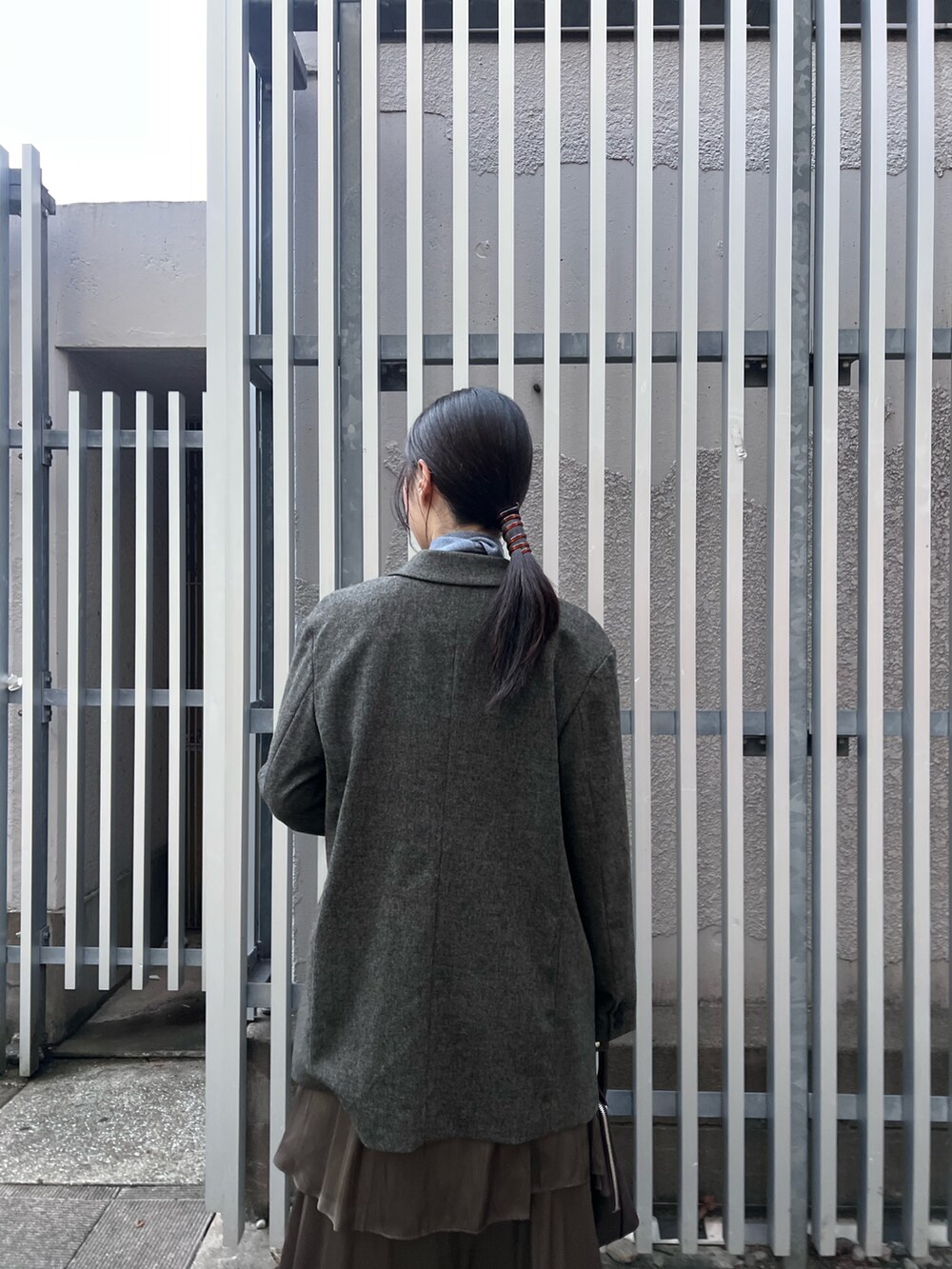 ブラック系のブーツ、ブルー系のニット/セーター、ブラウン系のテーラードジャケットを着用したレディースの秋コーディネートの5枚目の写真