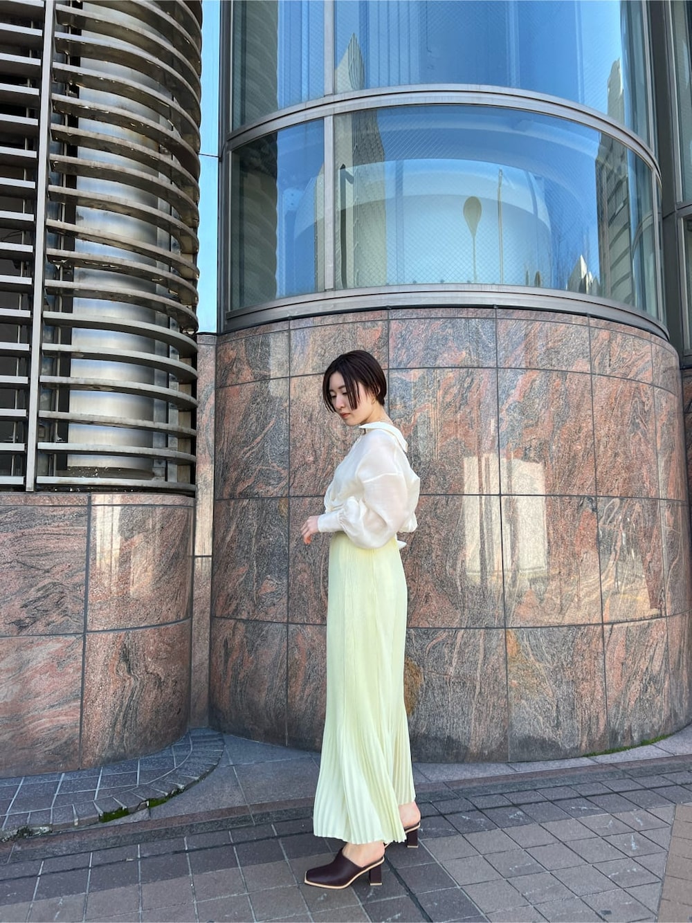 ホワイト系のシャツ/ブラウス、イエロー系のスカート、ホワイト系のハンドバッグを着用したレディースの春コーディネートの5枚目の写真