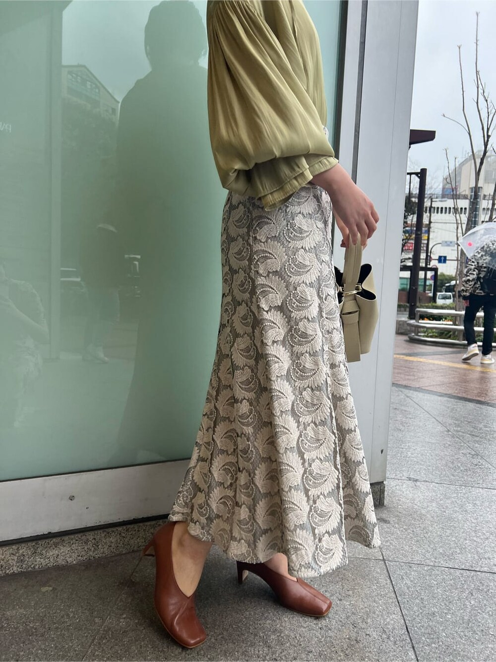 ホワイト系のハンドバッグ、ホワイト系のパンプス、グリーン系のシャツ/ブラウスを着用したレディースの春コーディネートの5枚目の写真