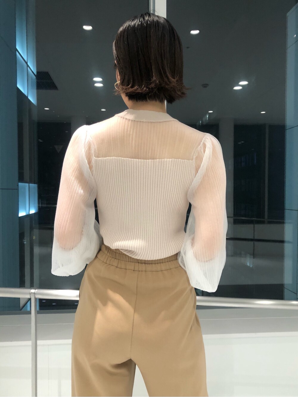 ベージュ系のその他アウター、パープル系のサンダル、パープル系のハンドバッグを着用したレディースの冬コーディネートの7枚目の写真