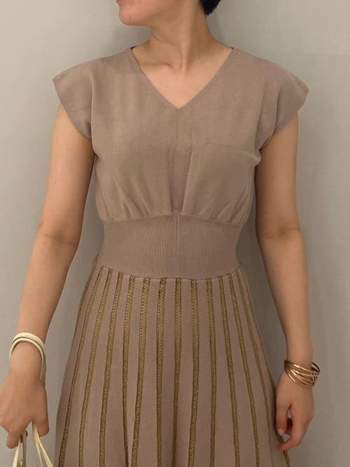 ホワイト系のハンドバッグ、ブラウン系のパンプス、ベージュ系のワンピースを着用したレディースの夏コーディネートの4枚目の写真