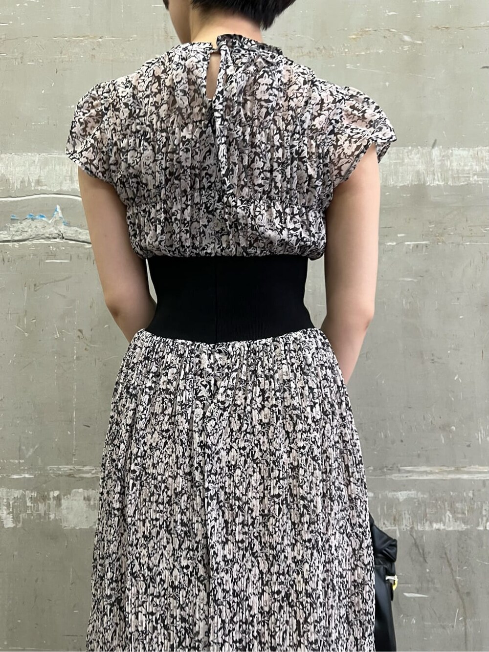 ブラウン系のパンプス、ブラック系のワンピース、ブラック系のハンドバッグを着用したレディースの夏コーディネートの5枚目の写真