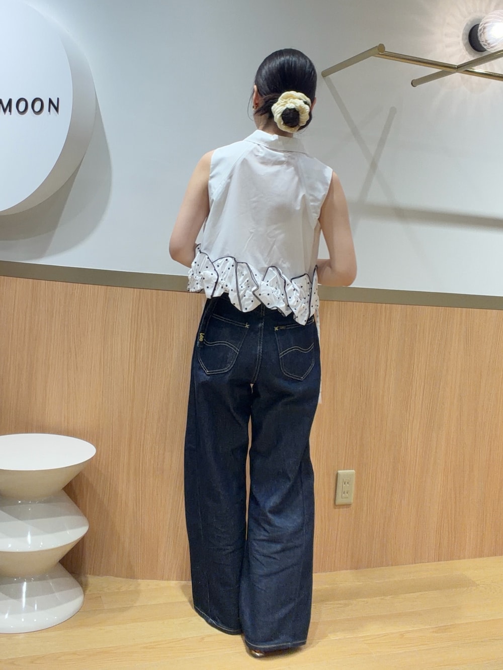 ブルー系のデニムパンツ、オレンジ系のサンダル、ホワイト系のシャツ/ブラウスを着用したレディースの夏コーディネートの2枚目の写真