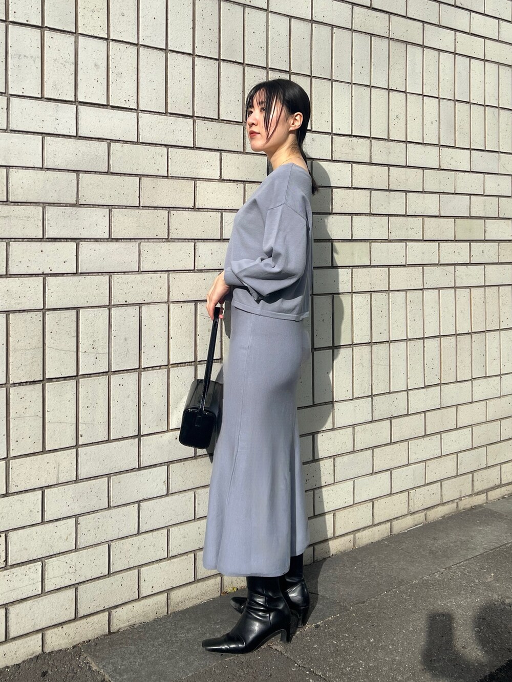 ブルー系のスカート、ブルー系のニット/セーターを着用したレディースの冬コーディネートの2枚目の写真