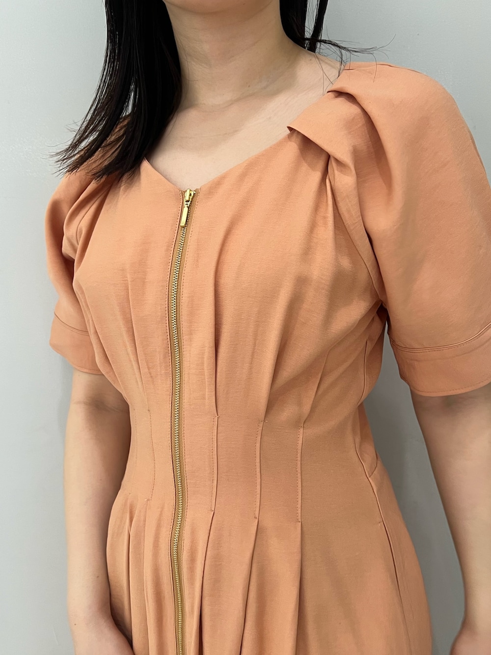 オレンジ系のワンピース、ホワイト系のサンダルを着用したレディースの春コーディネートの5枚目の写真