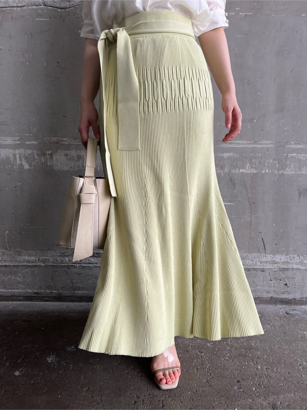 ホワイト系のハンドバッグ、グリーン系のサンダル、イエロー系のスカートを着用したレディースの夏コーディネートの8枚目の写真