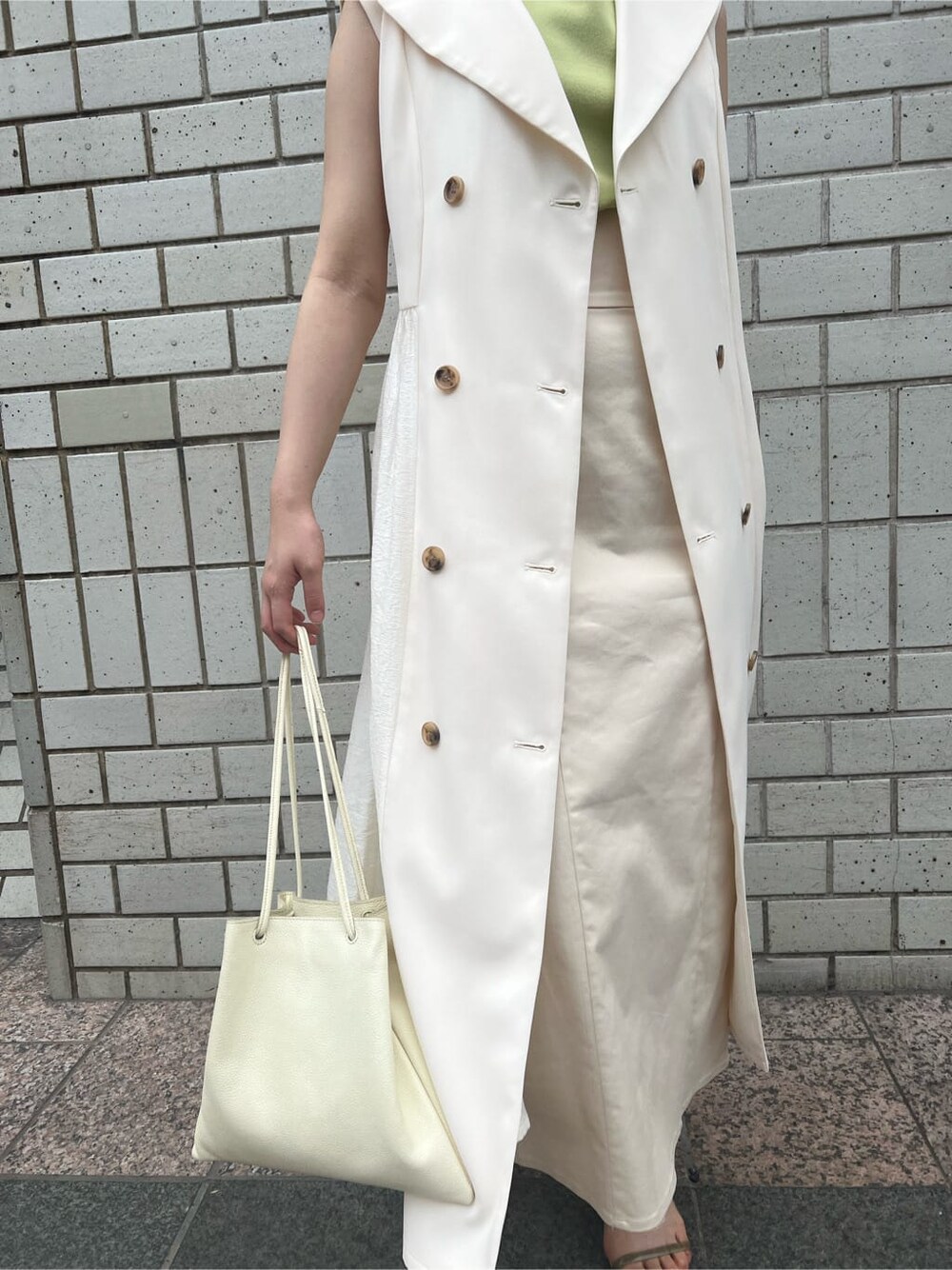 ホワイト系のハンドバッグ、ホワイト系のワンピース、グリーン系のサンダルを着用したレディースの春コーディネートの7枚目の写真