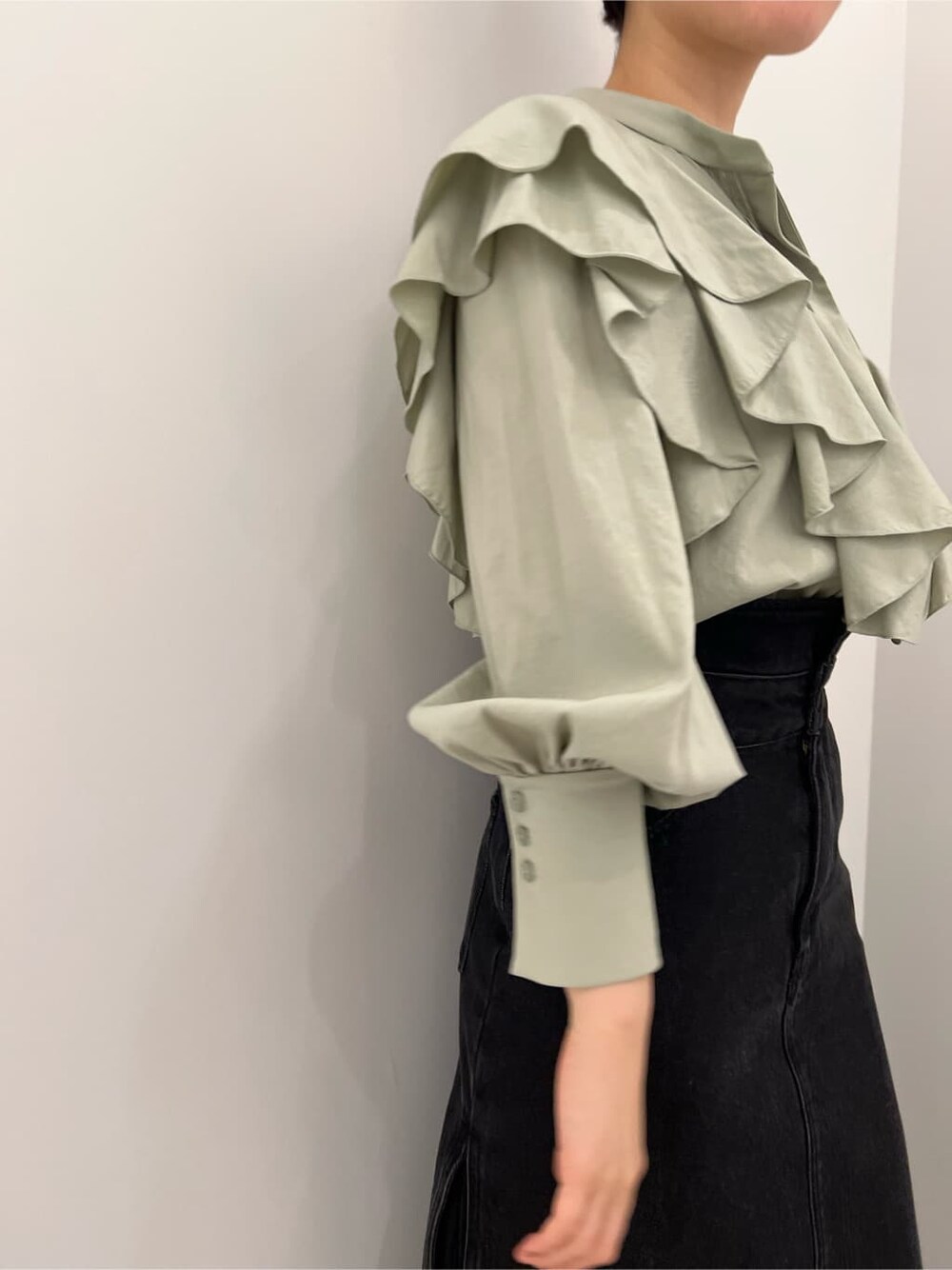 ベージュ系のその他シューズ、ブラック系のデニムスカート、グリーン系のシャツ/ブラウスを着用したレディースの冬コーディネートの4枚目の写真