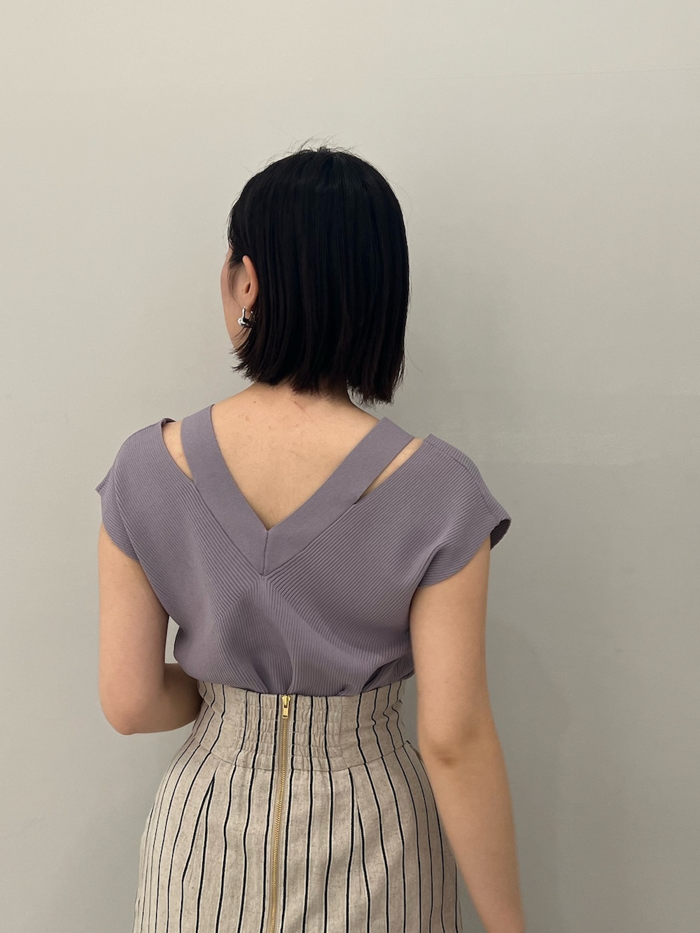 ブルー系のニット/セーター、シルバー系のパンプス、グレー系のスカートを着用したレディースの春コーディネートの5枚目の写真