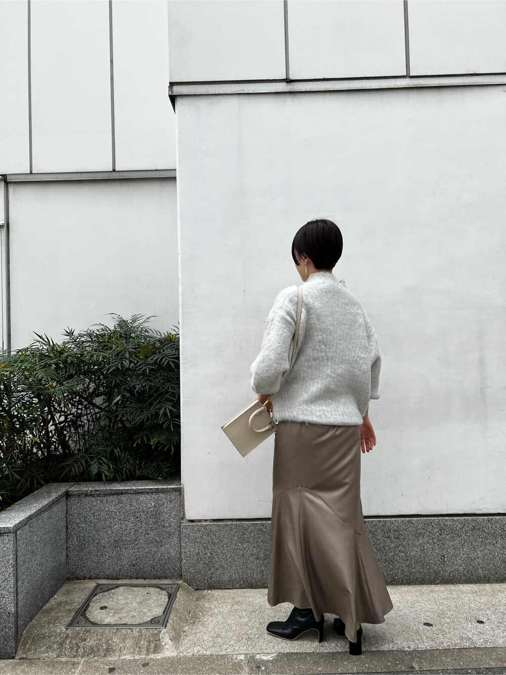 ベージュ系のスカート、ホワイト系のショルダーバッグ、ベージュ系のその他シューズを着用したレディースの冬コーディネートの4枚目の写真