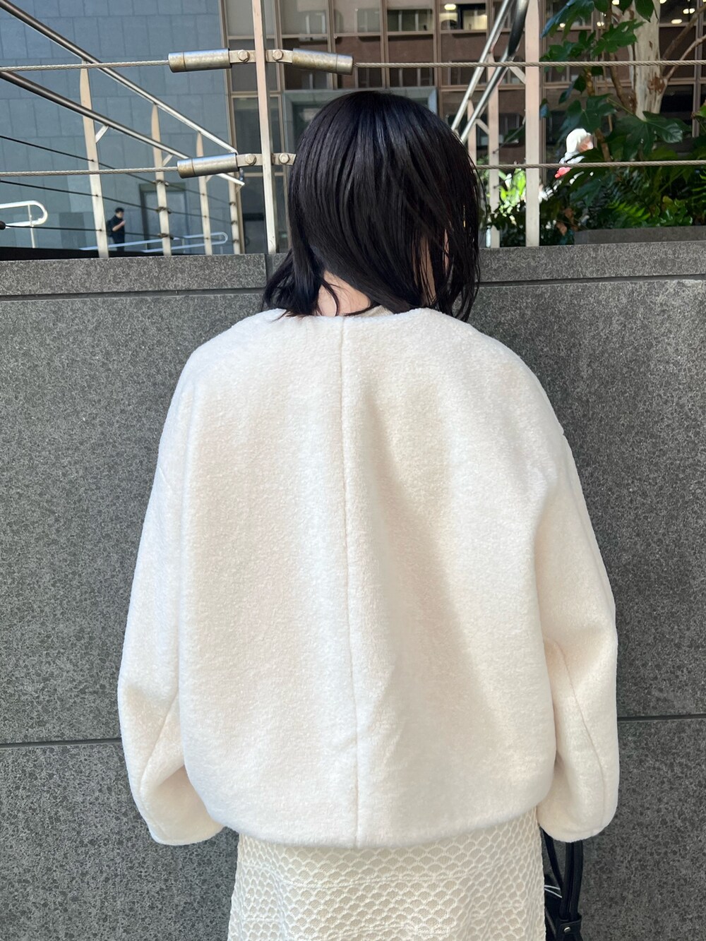 ホワイト系のブルゾン、ホワイト系のワンピース、ブラック系のブーツを着用したレディースの秋コーディネートの4枚目の写真