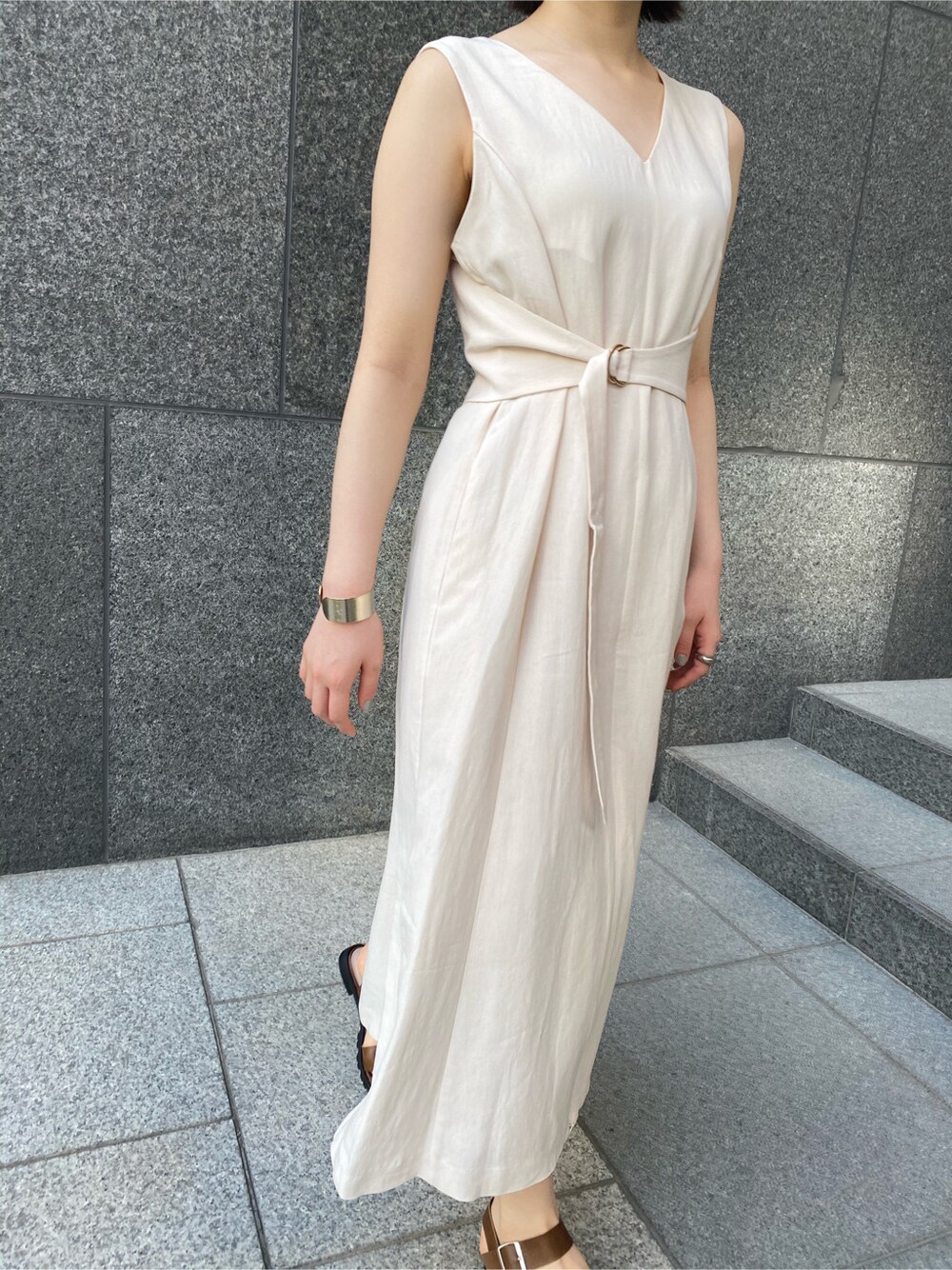 ブルー系のデニムパンツ、ブラウン系のサンダル、ベージュ系のワンピースを着用したレディースの春コーディネートの8枚目の写真