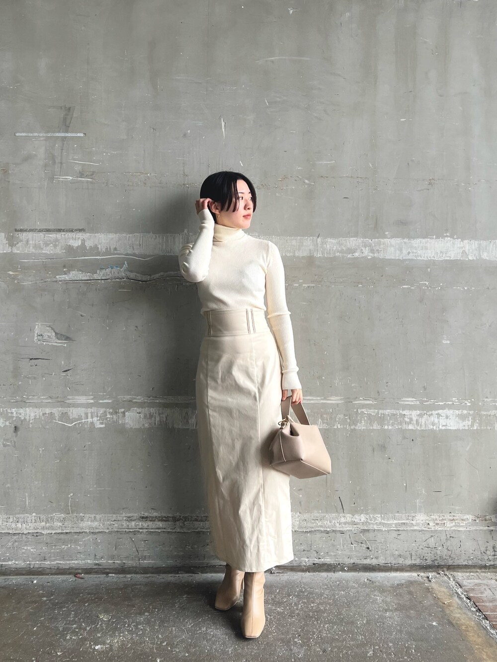 イエロー系のカーディガン/ボレロ、ベージュ系のブーツ、ホワイト系のニット/セーターを着用したレディースの秋コーディネートの6枚目の写真