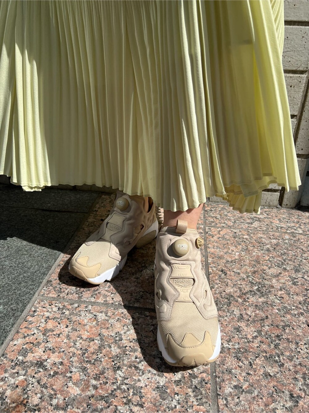 ブルー系のブルゾン、イエロー系のスカート、ベージュ系のニット/セーターを着用したレディースの春コーディネートの7枚目の写真