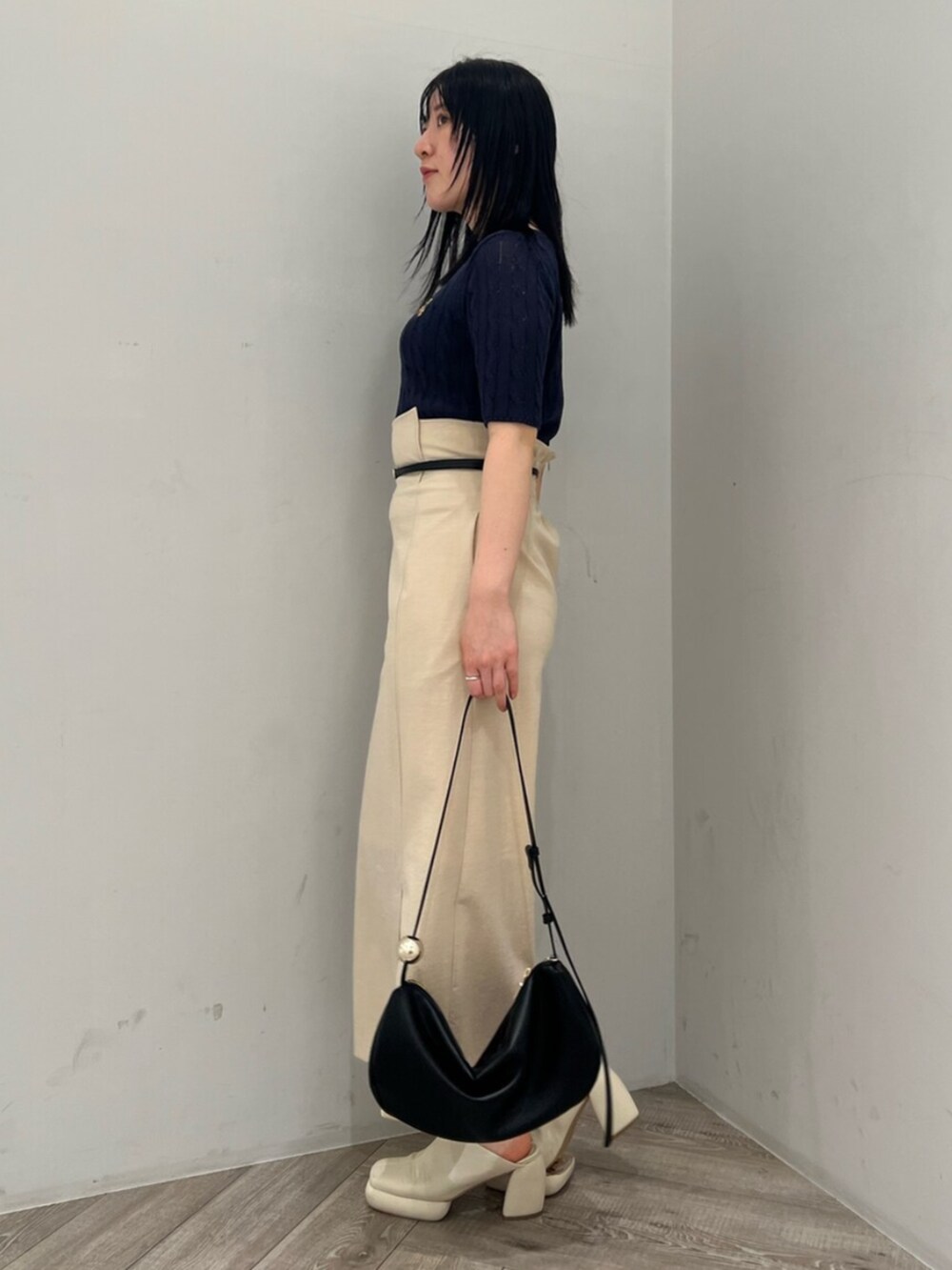 ブルー系のニット/セーター、ホワイト系のサンダル、ベージュ系のスカートを着用したレディースの春コーディネートの2枚目の写真