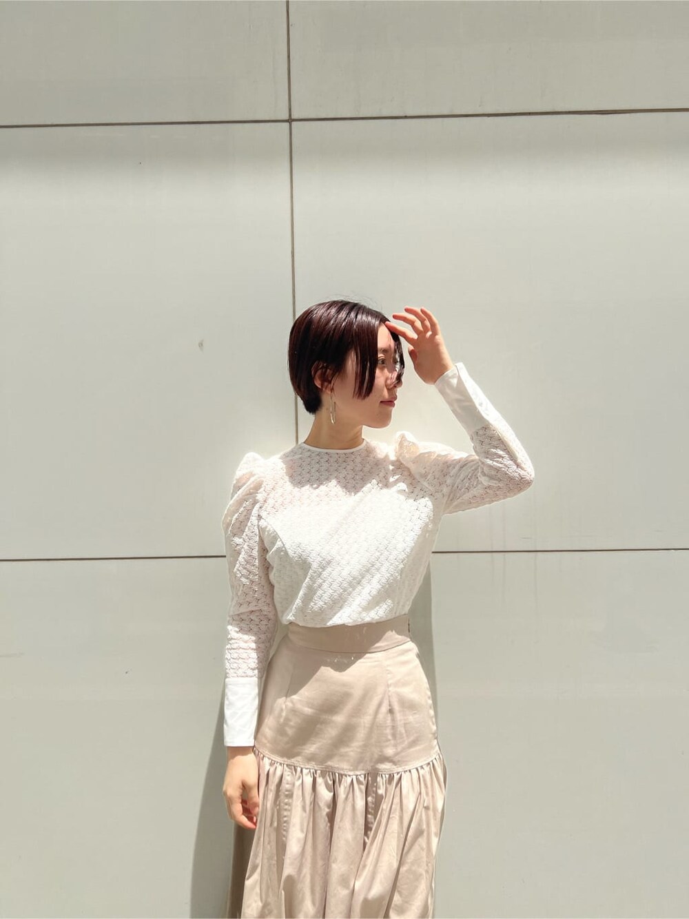 ベージュ系のスカート、ホワイト系のシャツ/ブラウス、シルバー系のピアス（両耳用）を着用したレディースの夏コーディネートの4枚目の写真