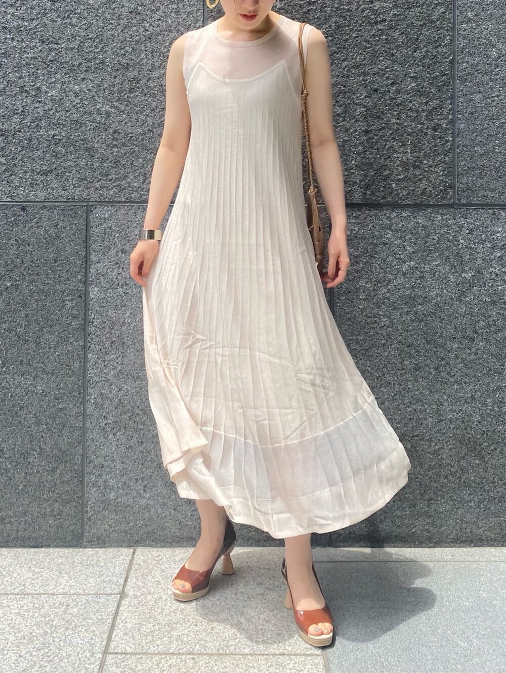 ブラウン系のパンプス、ホワイト系のワンピース、ベージュ系のショルダーバッグを着用したレディースの夏コーディネートの2枚目の写真