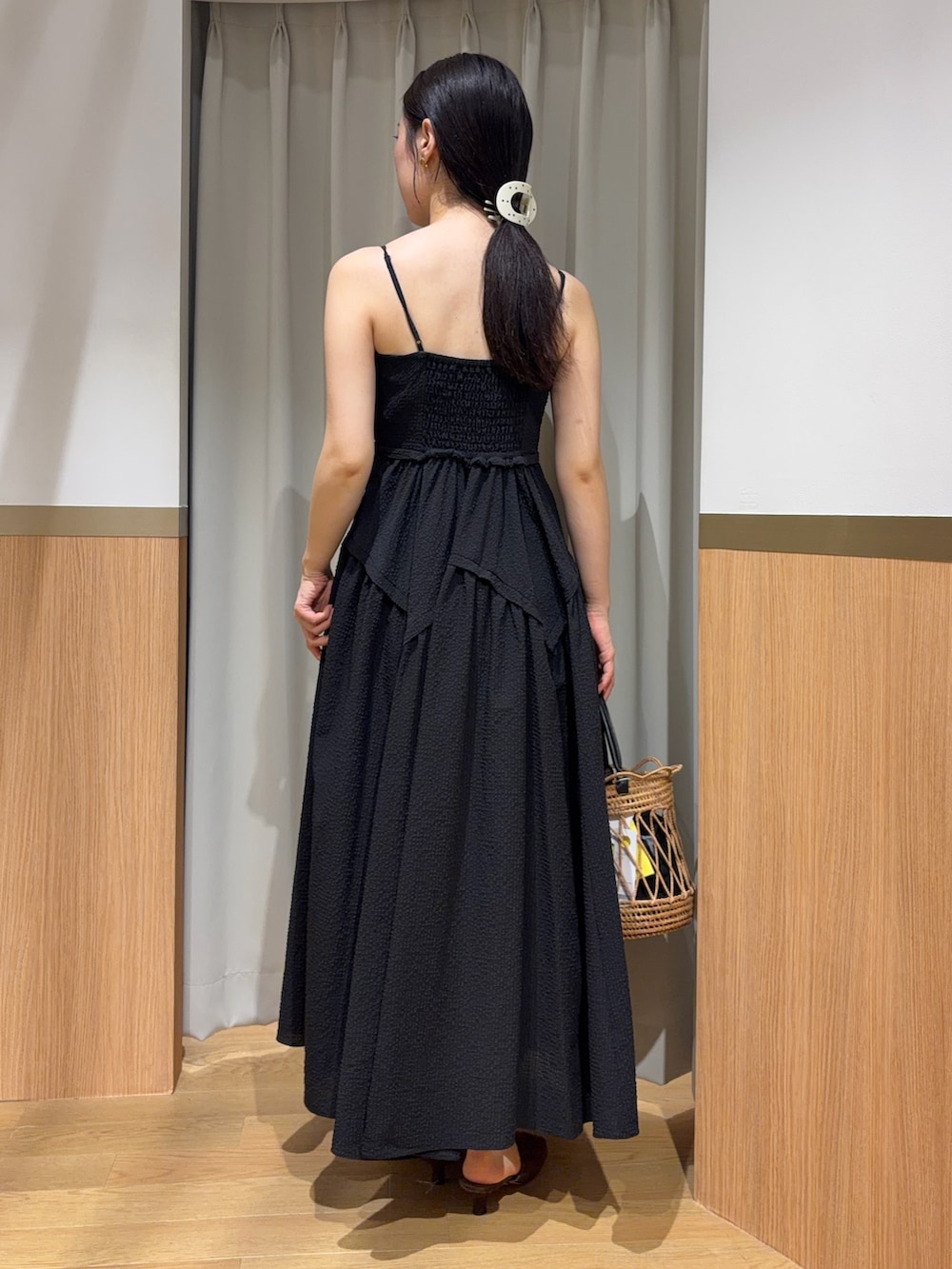 ブラック系のワンピース、ブラウン系のサンダル、ブラック系のハンドバッグを着用したレディースの夏コーディネートの3枚目の写真