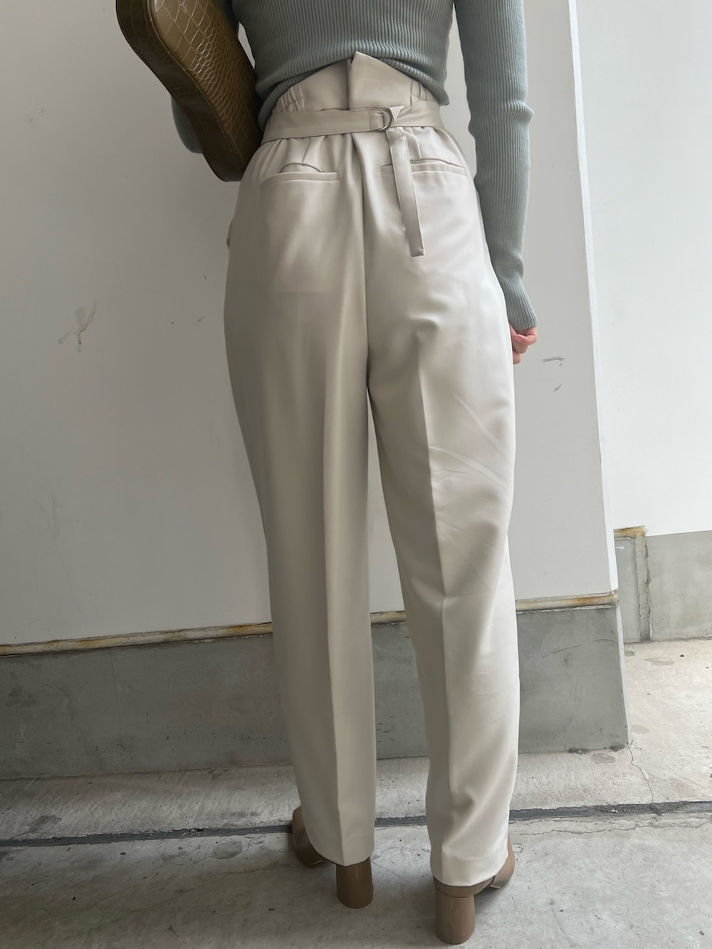 ベージュ系のブーツ、ホワイト系のスラックス、ホワイト系のニット/セーターを着用したレディースの冬コーディネートの9枚目の写真