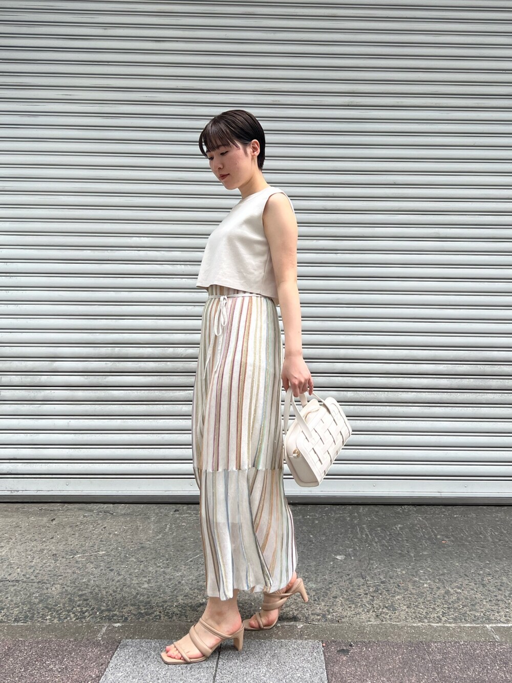 ホワイト系のショルダーバッグ、ベージュ系のサンダル、ホワイト系のワンピースを着用したレディースの春コーディネートの5枚目の写真