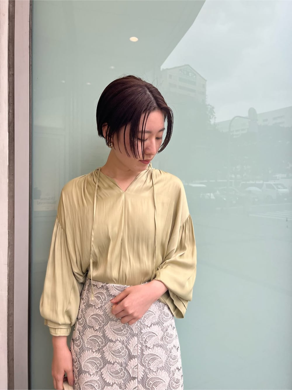 ホワイト系のハンドバッグ、ホワイト系のパンプス、グリーン系のシャツ/ブラウスを着用したレディースの春コーディネートの7枚目の写真