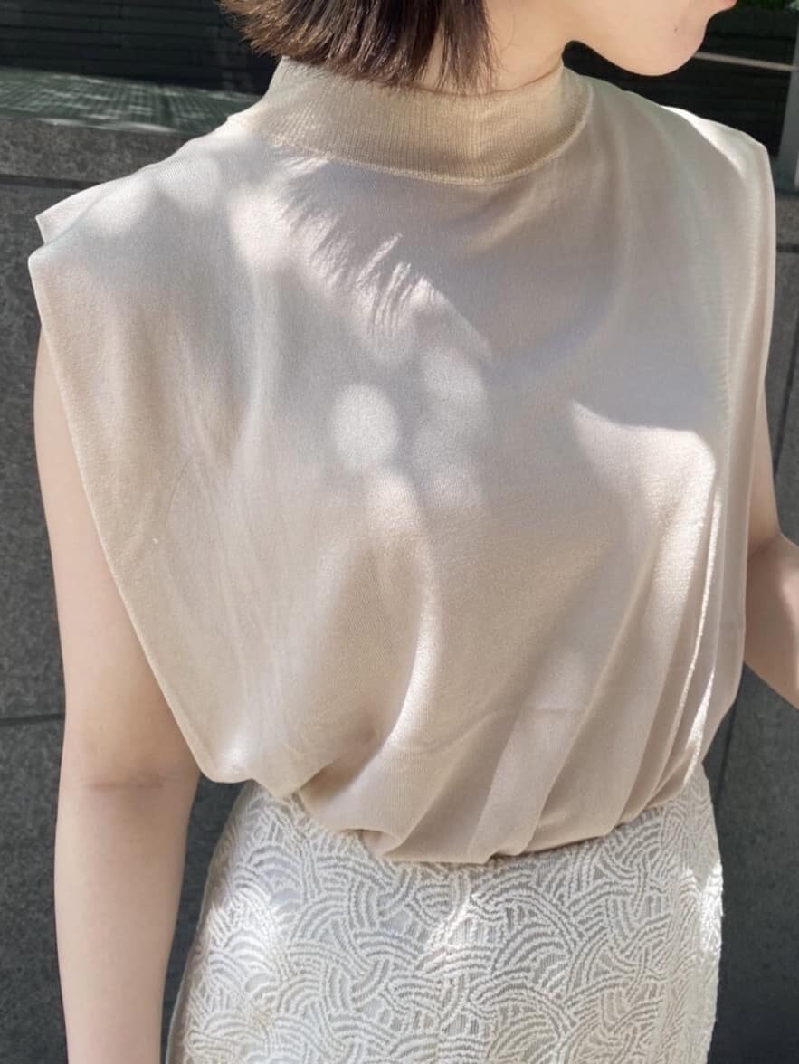 ベージュ系のニット/セーター、ホワイト系のハンドバッグ、ホワイト系のスカートを着用したレディースの夏コーディネートの3枚目の写真